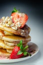 Pancakes stacked with bananas, strawberries and nuts, topped with chocolate and strawberry sauce Royalty Free Stock Photo