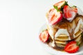 Pancakes stacked with strawberries, topped with  chocolate sauce and yoghurt Royalty Free Stock Photo