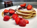 Pancakes with strawberries, jam and sugar on white plate Royalty Free Stock Photo