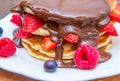 Dish with pancakes and strawberry,raspberry and blueberry and chocolate