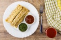 Pancakes with stuffing in plate, fork, tomato juice in glass