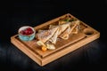 Pancakes with sugar powder and jam on a wooden board. Dark table, empty space. Maslenitsa, russian carnival