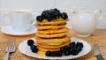 Pancakes. Sweet honey pouring over pancakes with berry fruit. Tasty breakfast food