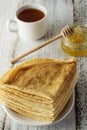 Pancakes. Thin pancakes. Russian bliny. Healthy tasty breakfast - pancakes, a cup of tea and honey Royalty Free Stock Photo