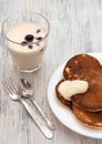 Pancakes with yoghurt and berries on the plate. Yogurt in a glass with berries .