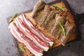 Pancetta Italian is a salt cured pork belly salume closeup on the wooden board. Horizontal top view