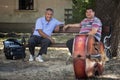 PANCEVO, SERBIA - AUGUST 1, 2015: Two Serbian musicians one accordeonist, one contrabassist having a break before a performance Royalty Free Stock Photo