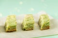 Pandan cake. Pieces of green cake with Pistachio nuts on paper. Korean dessert of Matcha tea. Vegan food