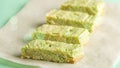 Pandan cake. Pieces of green cake with Pistachio nuts on paper. Korean dessert of Matcha tea. Vegan food