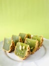 Pandan moon cake with seeds cut into eighths , green background. Vertical. Royalty Free Stock Photo