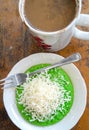 Pandan pancake topped with shredded chedar cheese with a cup of coffee
