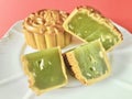 Pandan seeds moon cake with a portion cutout on red background. details. Royalty Free Stock Photo