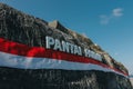 Pandawa beach cliff wall in Bali which is decorated with the red and white cloth symbol of the Indonesian fl