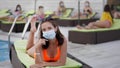 Pandemic, girl in swimsuit resting on sun lounger by pool and complies with new regulations wears protective medical