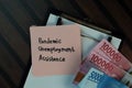 Pandemic Unemployment Assitance write on sticky notes isolated on Wooden Table. Business or Finance concept Royalty Free Stock Photo