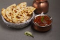 Paneer Butter Masala or Cheese Cottage Curry, popular Indian lunch / dinner menu served with naan or roti on a moody background,