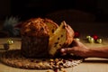 Panettone on a black background and man hand taking a slice. Royalty Free Stock Photo