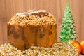 a panettone with christmas ornaments and wooden background in brown color