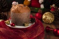 Panettone on a white plate wrapped in red tulle on a wooden table with Christmas decoration, copy space Royalty Free Stock Photo