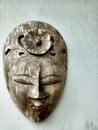 A traditional face mask made of carved wood typical of Indonesian Java on a wall of a house