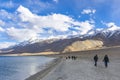 Ladakh landscape with tourists walking around Pangong Tso lake, in india