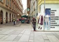 Panhandler standing next to a fashion store