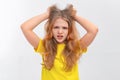Panicking freaked out teen girl wearing casual yellow tshirt screaming shocked and scared holding hands on head popping eyes at Royalty Free Stock Photo