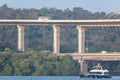 A boat sailing on the Mandovi river below a double decker bridge in the city of Panaji