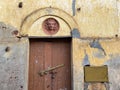 An old, abandoned house with a beautiful Portuguese era carving above a wooden door in the city