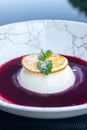 Panna cotta with orange slice, mint and raspberry sauce. Delicious light dessert