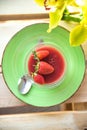 Pannacotta with strawberries in a cup on a wooden background with flowers Royalty Free Stock Photo