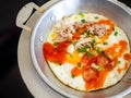 Panned egg food with sausage and pork chops in a metal dish