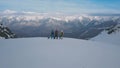 Panning shot group of active sports people with snowboarding and skiing standing on top of mountain