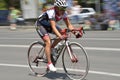 Panning of a beautiful girl riding bicycle in a sunny day, competing for Road Grand Prix event, a high-speed circuit race