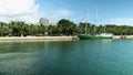 Panning footage of a beautiful summer landscape at Maurice A. Ferre Park with blue ocean water, a ship docked, lush green palm