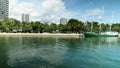 Panning footage of a beautiful summer landscape at Maurice A. Ferre Park with blue ocean water, a ship docked, lush green palm