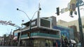 Panning footage of the Fremont East District sign with nightclubs, people walking, restaurants and cars driving on the street