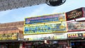 panning footage of Tacos and Miches, the Souvenir Supermart, 322 Pizza Bar with people walking at the Fremont Street Experience