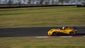 A yellow Lotus sportscar speeding round corners