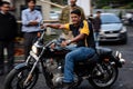 Panning photo of man riding Harley Davidson motorbike on the road with head lights on. Blur movement of sporty bike on the street