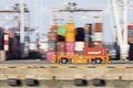 Panning shot of AGV carrying a container on quay of large port terminal