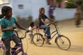 Panning shot of blurring and freezing effect of a girls chidren riding the bicycles.