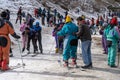 Panning shot of crowd of people in winter wear playing in snow, sking, sliding, at snow point in lahul, manali solang a