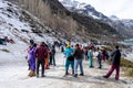 Panning shot of crowd of people in winter wear playing in snow, sking, sliding, at snow point in lahul, manali solang a