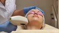 Panning up shot of doctor or therapist administering fractional skin laser treatment to resurface and rejuvenate a Royalty Free Stock Photo