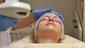 Panning up shot of doctor or therapist administering fractional skin laser treatment to resurface and rejuvenate a Royalty Free Stock Photo