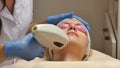 Panning up shot of doctor or therapist administering fractional skin laser treatment to resurface and rejuvenate a Royalty Free Stock Photo