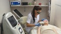 Panning up shot of doctor or therapist administering fractional skin laser treatment to resurface and rejuvenate a Royalty Free Stock Photo