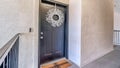 Pano Apartment unit with white wreath dark gray door and doormat at the entrance