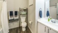 Pano Bathroom interior with over-the-toilet storage rack and wooden flooring Royalty Free Stock Photo